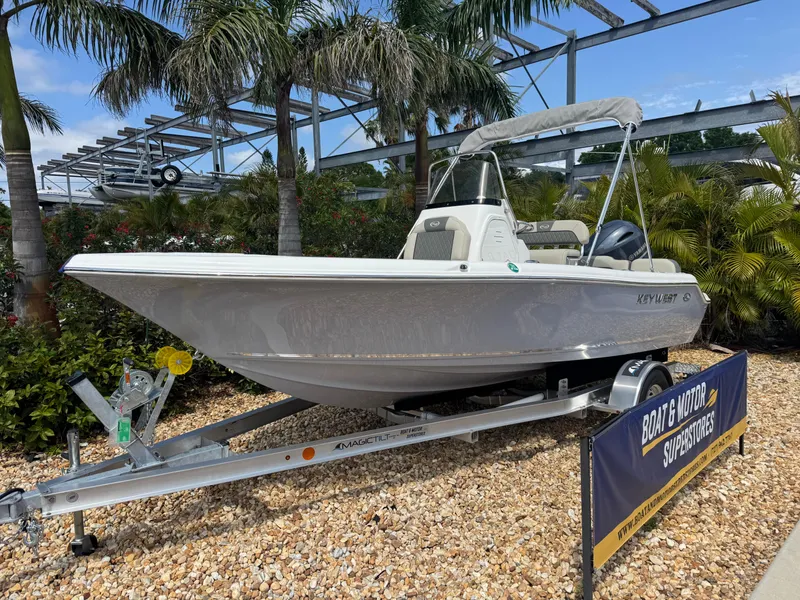 Slide: The Image of 2025 Key West 189 FS boat on trailer, displayed outdoors with palm trees. - 2
