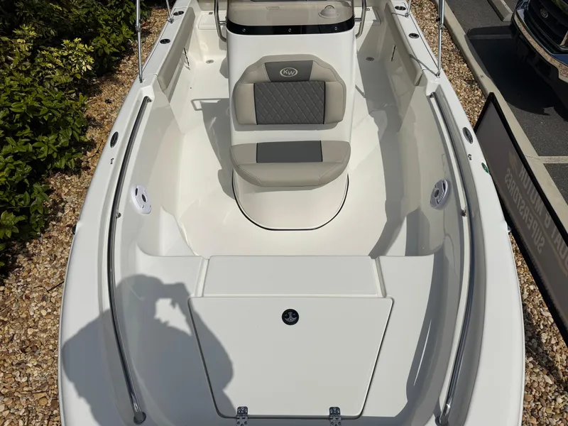 Slide: The Image of 2025 Key West 189 FS boat interior with seating and storage, displayed outdoors. - 23