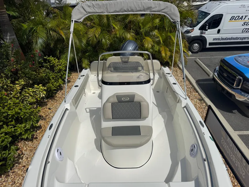 Slide: The Image of 2025 Key West 189 FS boat with seating, parked near lush greenery and vehicles. - 24