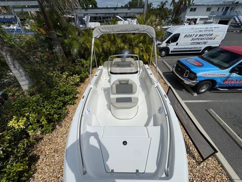 Slide: The Image of 2025 Key West 189 FS boat with canopy, parked near tropical plants and vehicles. - 25