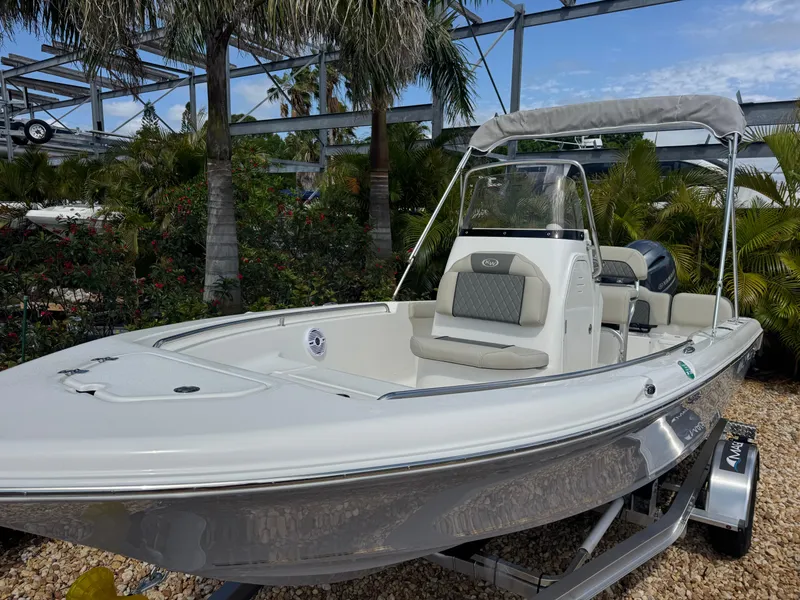 Slide: The Image of 2025 Key West 189 FS boat with canopy, parked outdoors near palm trees. - 3