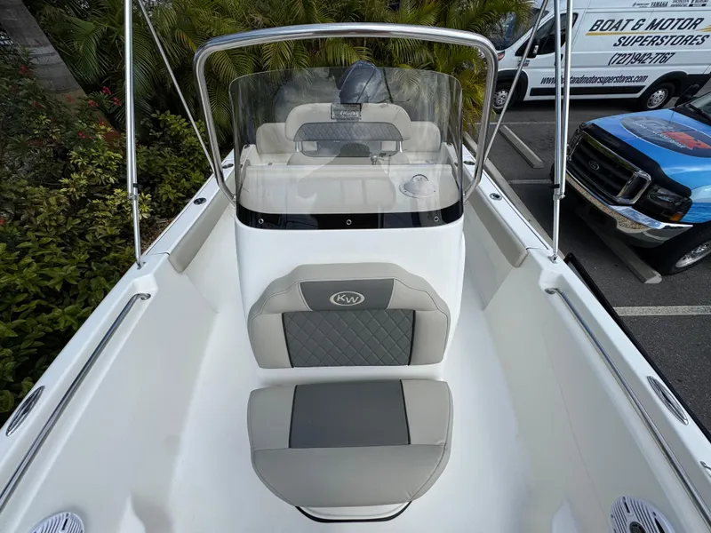Slide: The Image of 2025 Key West 189 FS boat interior with seating and windshield, parked outdoors. - 30
