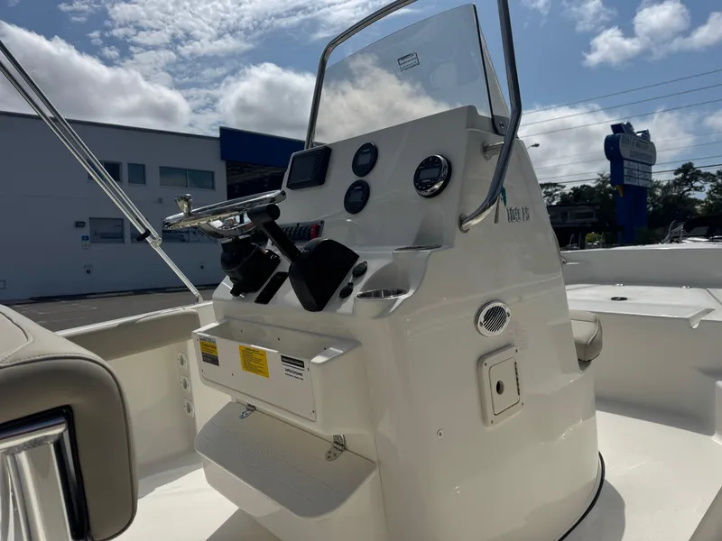 Slide: The Image of 2025 Key West 189 FS boat console with steering wheel and gauges under a sunny sky. - 8