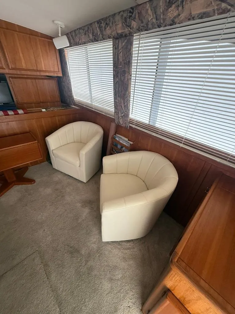 Slide: The Image of Interior of 1989 Post 43 Sport Fisherman with white chairs and wooden cabinetry. - 13
