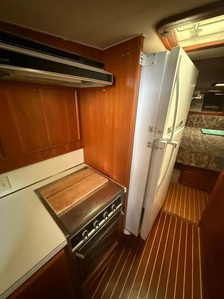Slide: The Image of 1989 Post 43 Sport Fisherman kitchen with stove, fridge, and wood paneling. - 17