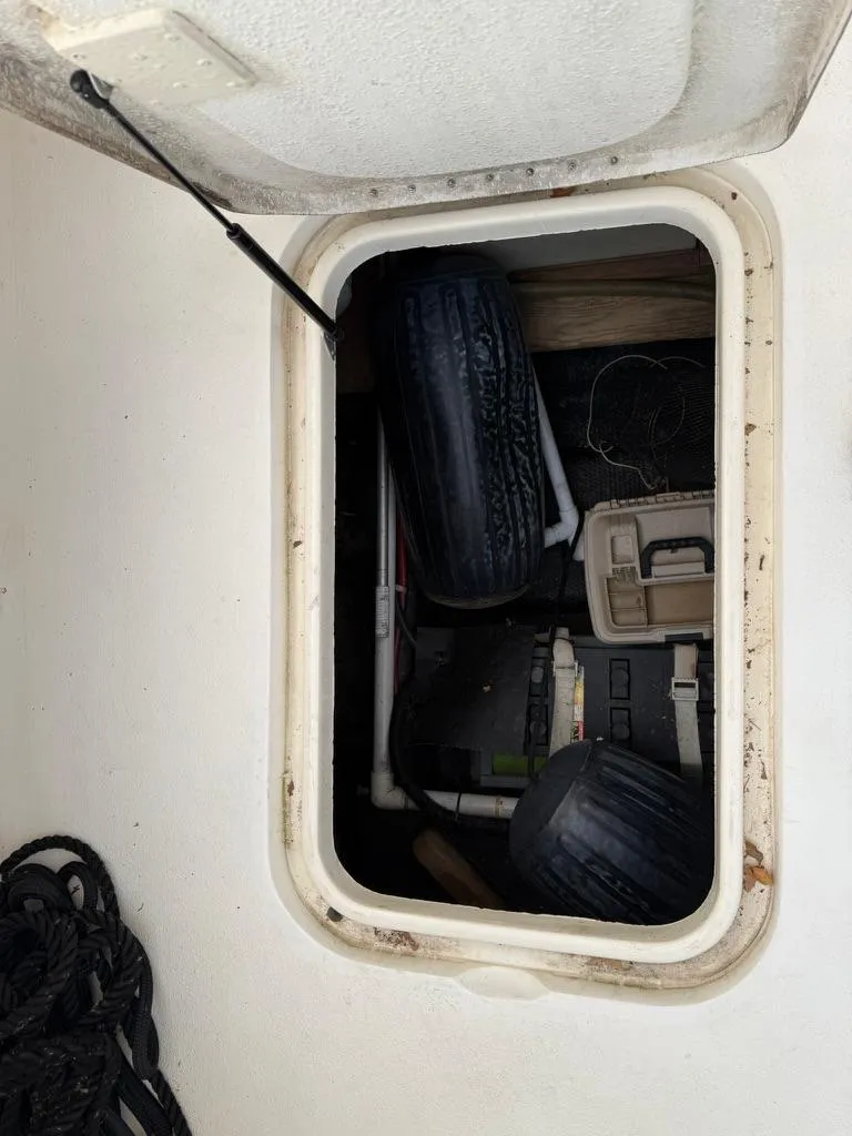 Slide: The Image of Hatch storage on 1989 Post 43 Sport Fisherman boat with tires and equipment. - 29