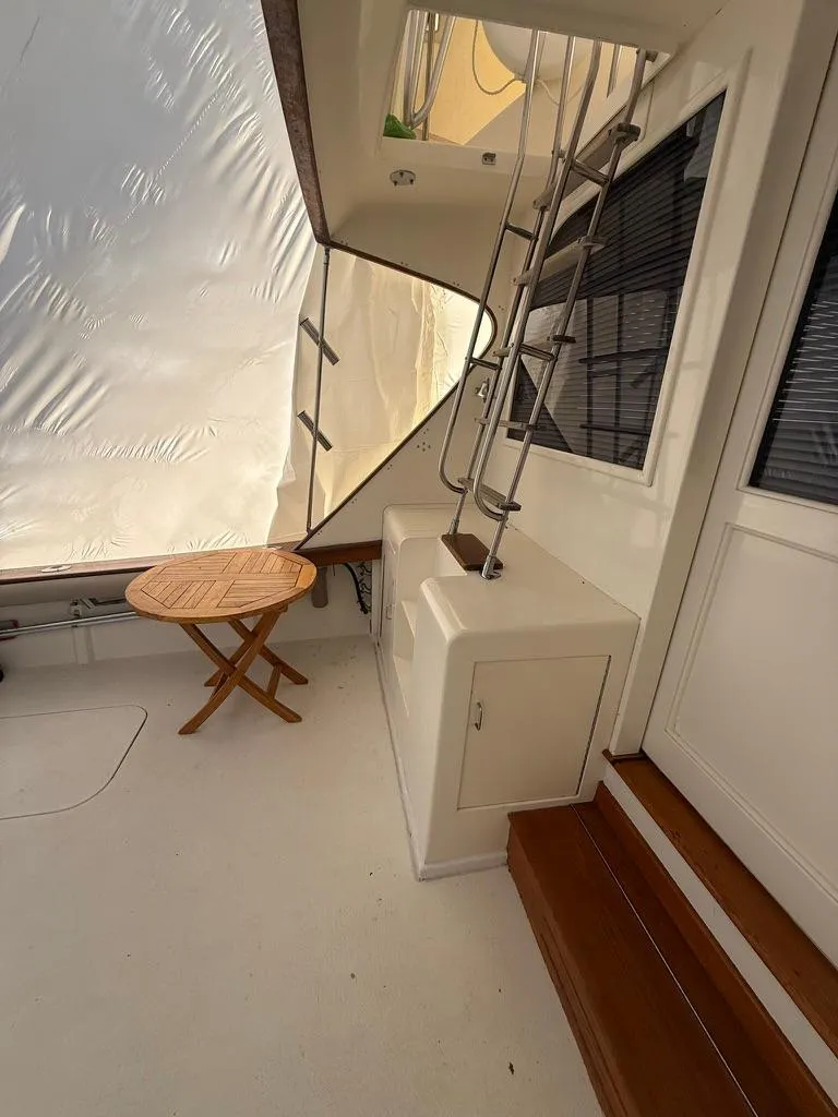 Slide: The Image of 1989 Post 43 Sport Fisherman boat interior with wooden table and stairs. - 3