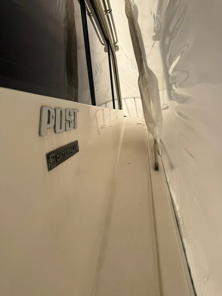 Slide: The Image of 1989 Post 43 Sport Fisherman boat side view with logo and sleek design. - 7