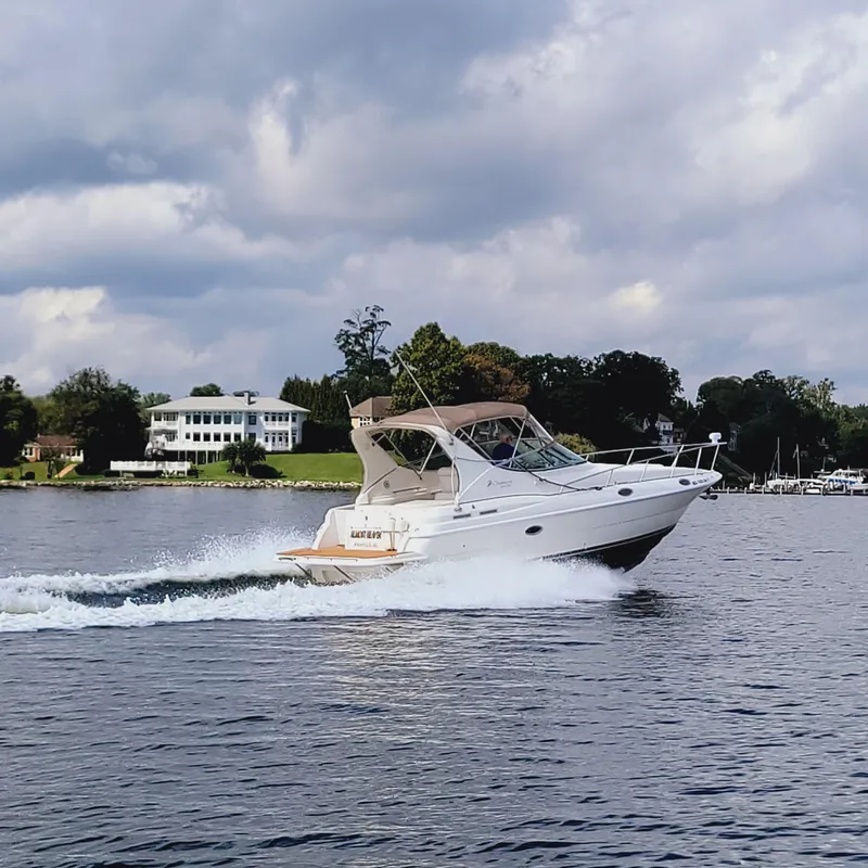 Slide: The Image of 1999 Cruisers Yachts 3075 Rogue cruising on a scenic lake under cloudy skies. - 10
