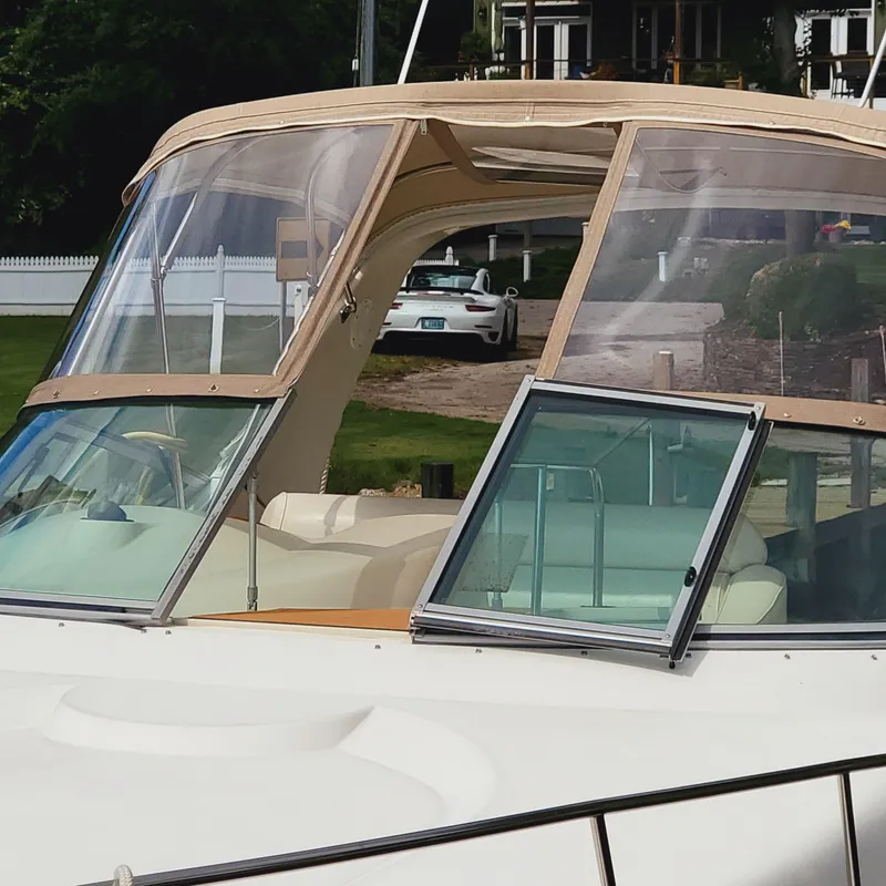 Slide: The Image of 1999 Cruisers Yachts 3075 Rogue with beige canopy and open cabin window. - 13