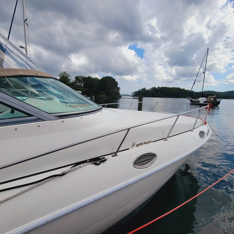 Slide: The Image of 1999 Cruisers Yachts 3075 Rogue docked on a calm lake under cloudy skies. - 16