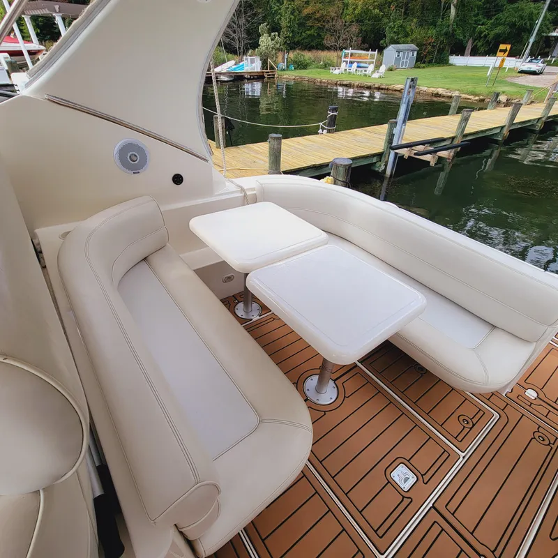 Slide: The Image of 1999 Cruisers Yachts 3075 Rogue interior with white seating and table, dockside view. - 21