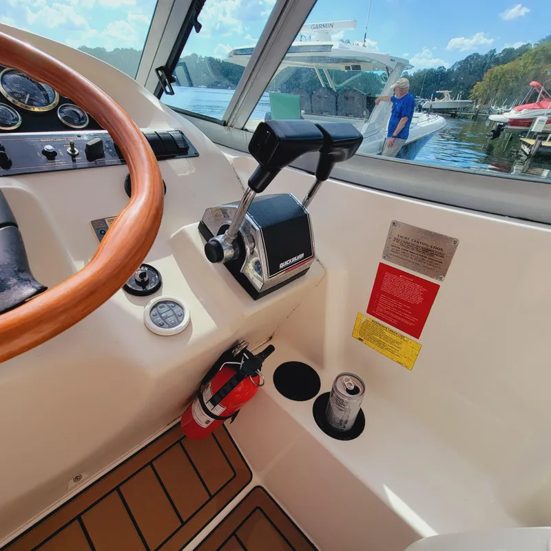 Slide: The Image of 1999 Cruisers Yachts 3075 Rogue helm with controls, steering wheel, and fire extinguisher. - 24