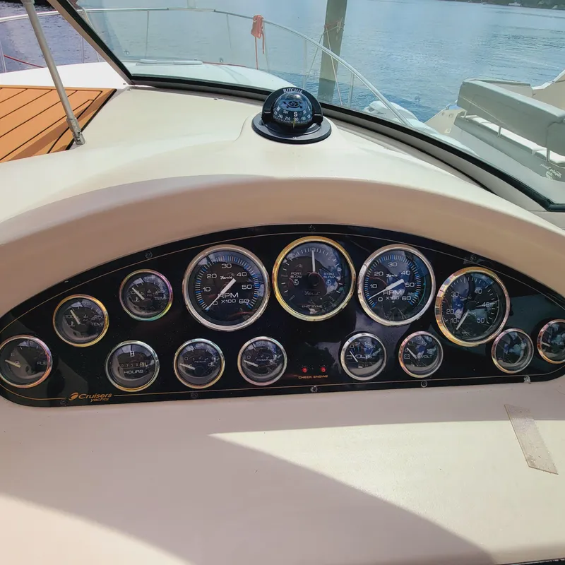 Slide: The Image of Dashboard of a 1999 Cruisers Yachts 3075 Rogue with multiple gauges and a compass. - 29