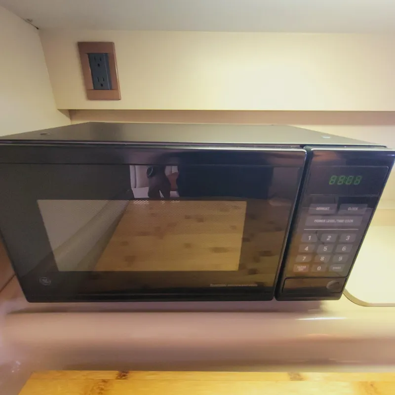 Slide: The Image of A black microwave oven on a kitchen counter with digital display and control panel. - 42