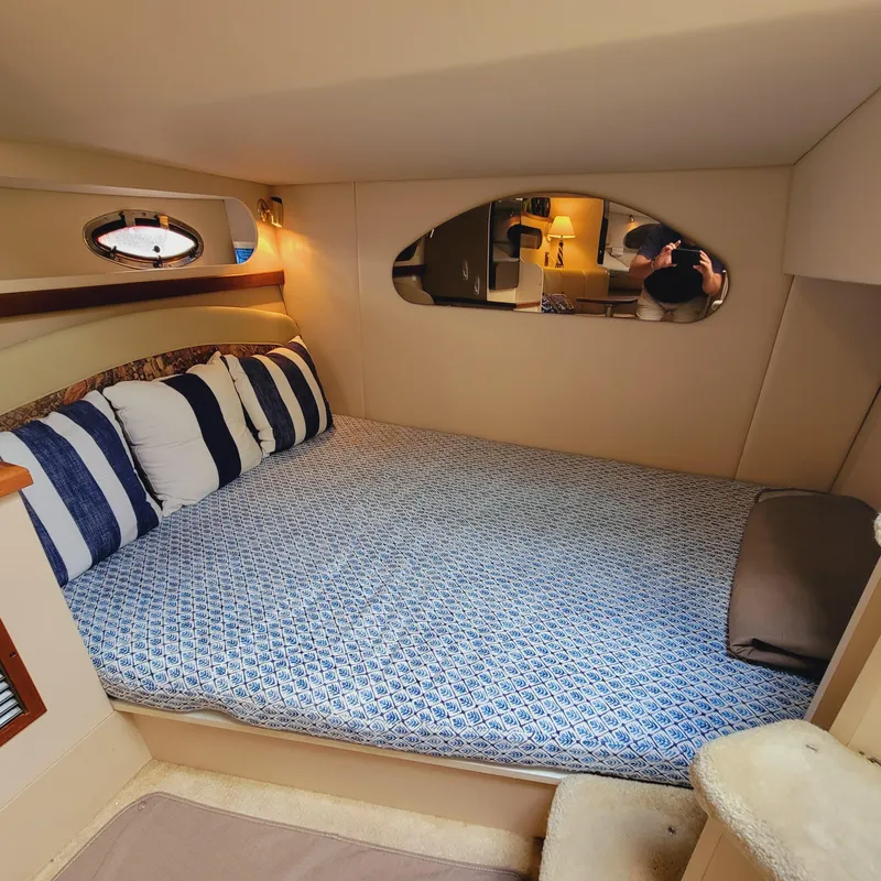 Slide: The Image of 1999 Cruisers Yachts 3075 Rogue cabin with cozy bed and striped pillows. - 44