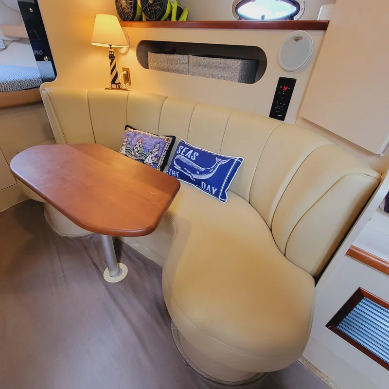 Slide: The Image of 1999 Cruisers Yachts 3075 Rogue interior with beige seating and wooden table. - 48