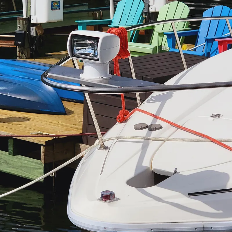 Slide: The Image of 1999 Cruisers Yachts 3075 Rogue boat docked with colorful chairs in background. - 9