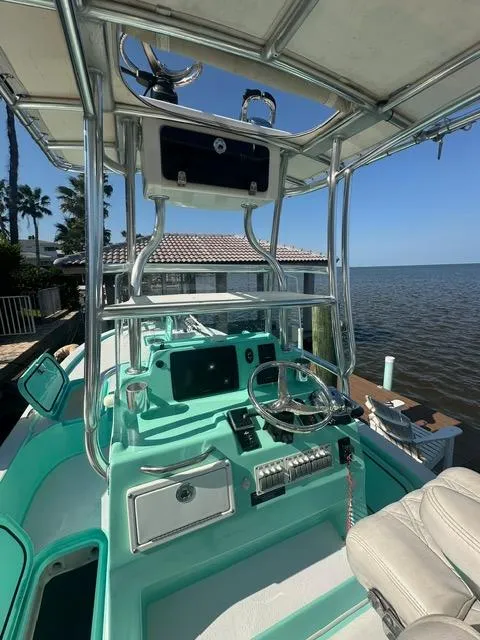 Slide: The Image of 2022 Shallow Sport 28 X3 boat with teal interior, docked by the water. - 12