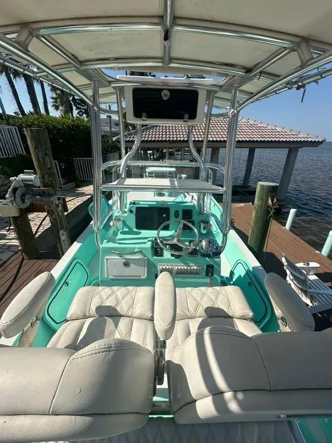 Slide: The Image of 2022 Shallow Sport 28 X3 boat with dual seating and control panel, docked by the water. - 15