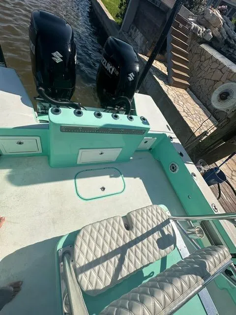 Slide: The Image of 2022 Shallow Sport 28 X3 boat with dual Suzuki engines, docked near stone pathway. - 17