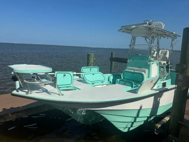 Slide: The Image of 2022 Shallow Sport 28 X3 boat docked by the water, featuring a sleek design and mint green accents. - 3