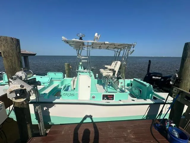 Slide: The Image of 2022 Shallow Sport 28 X3 boat docked by the sea under clear blue skies. - 4