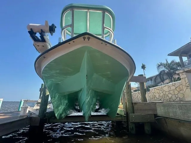 Slide: The Image of 2022 Shallow Sport 28 X3 boat on lift, showcasing hull design and vibrant color. - 6