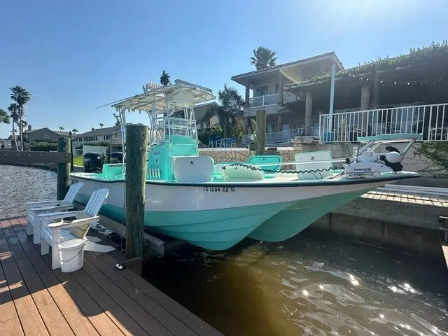 Slide: The Image of 2022 Shallow Sport 28 X3 boat docked by waterfront homes under clear sky. - 7