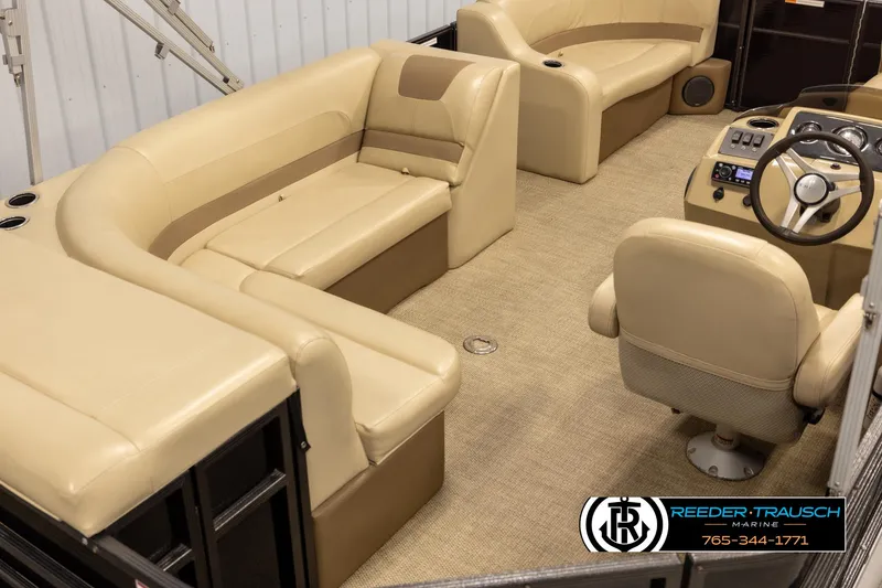 Slide: The Image of 2017 Crest 200 L CPT pontoon boat interior with beige seating and steering console. - 12