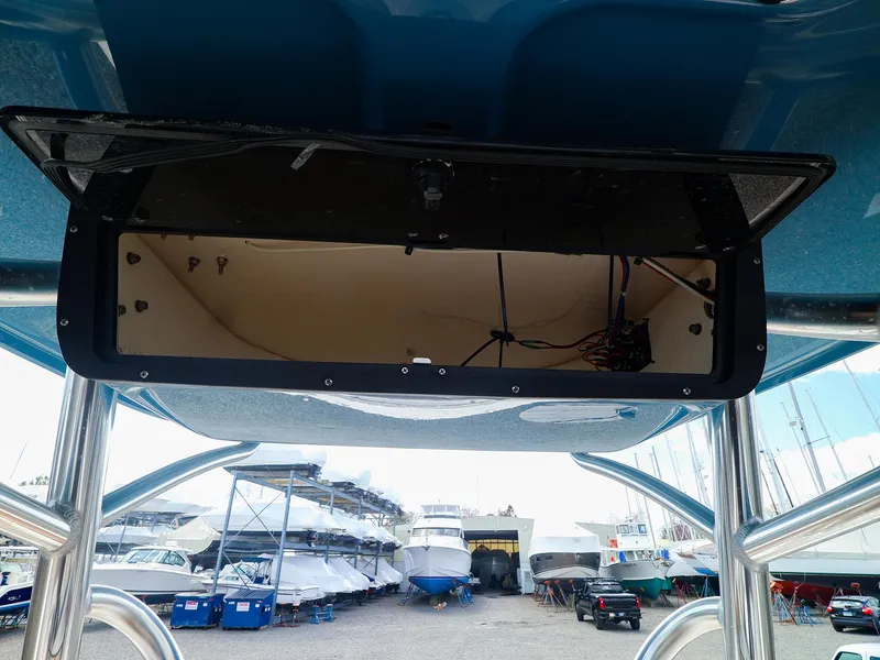 Slide: The Image of 2022 Pioneer 222 Islander boat storage compartment, marina background with multiple boats. - 10