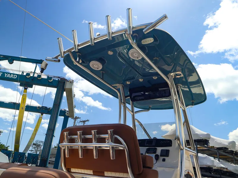Slide: The Image of 2022 Pioneer 222 Islander boat with T-top and rod holders under a clear blue sky. - 14