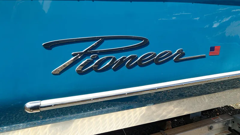 Slide: The Image of Blue 2022 Pioneer 222 Islander boat with logo and American flag emblem. - 16