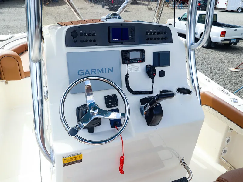 Slide: The Image of 2022 Pioneer 222 Islander boat dashboard with Garmin navigation system and steering wheel. - 2