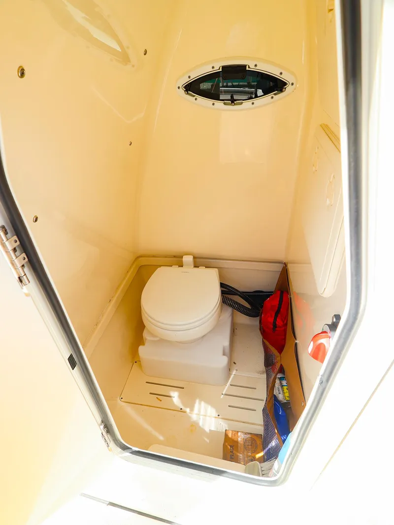Slide: The Image of 2022 Pioneer 222 Islander boat interior with compact toilet and storage space. - 21