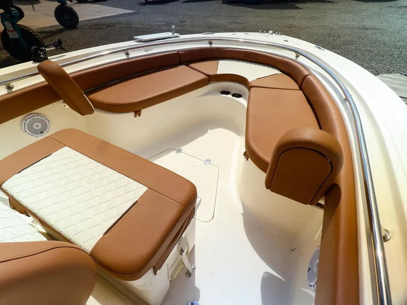 Slide: The Image of 2022 Pioneer 222 Islander boat interior with tan cushioned seating and white deck. - 4