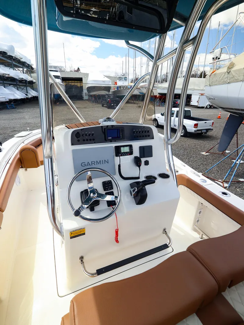 Slide: The Image of 2022 Pioneer 222 Islander boat console with Garmin navigation, docked in a marina. - 5