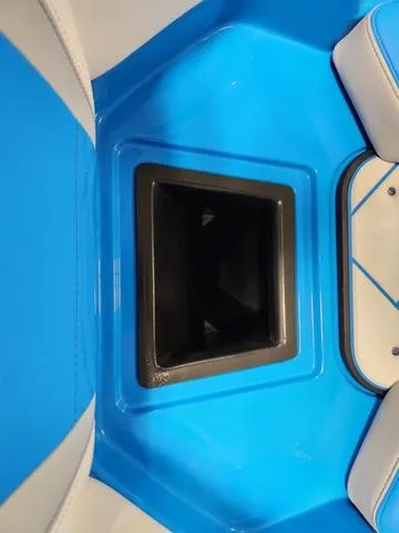 Slide: The Image of 2023 Malibu 26 LSV boat interior with blue seating and storage compartment. - 12