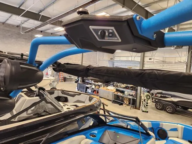 Slide: The Image of 2023 Malibu 26 LSV boat interior with blue accents in a showroom. - 28