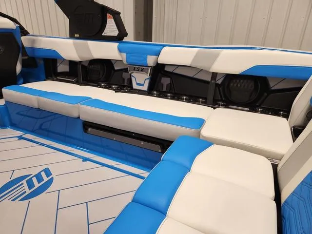 Slide: The Image of 2023 Malibu 26 LSV boat interior with blue and white seating. - 34