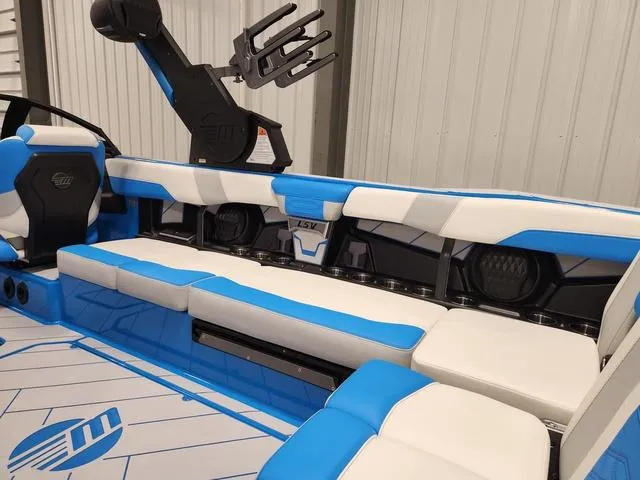 Slide: The Image of 2023 Malibu 26 LSV boat interior with blue and white seating, modern design. - 48
