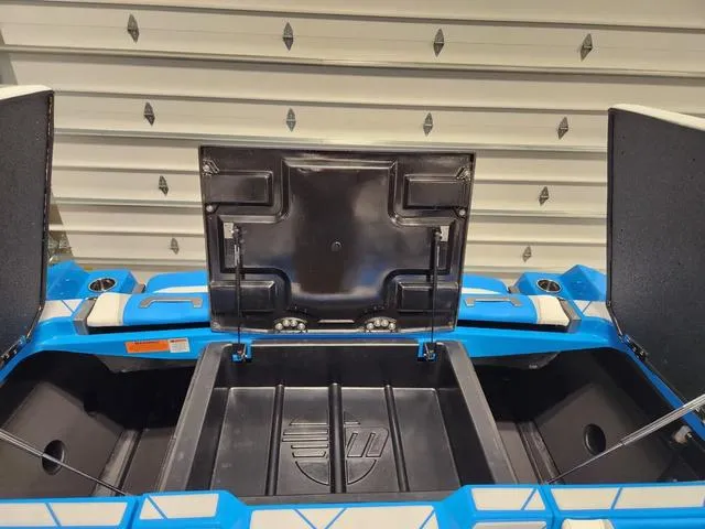 Slide: The Image of 2023 Malibu 26 LSV boat storage compartments open in a garage setting. - 7