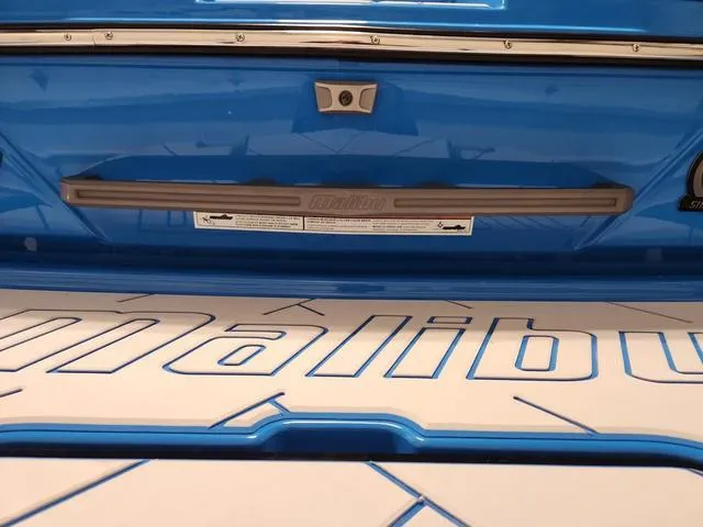 Slide: The Image of 2023 Malibu 26 LSV boat, blue exterior, detailed branding on deck. - 9