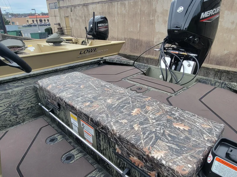 Slide: The Image of 2025 Tracker Grizzly 1860 CC boat with camo seating and Mercury outboard motor. - 10
