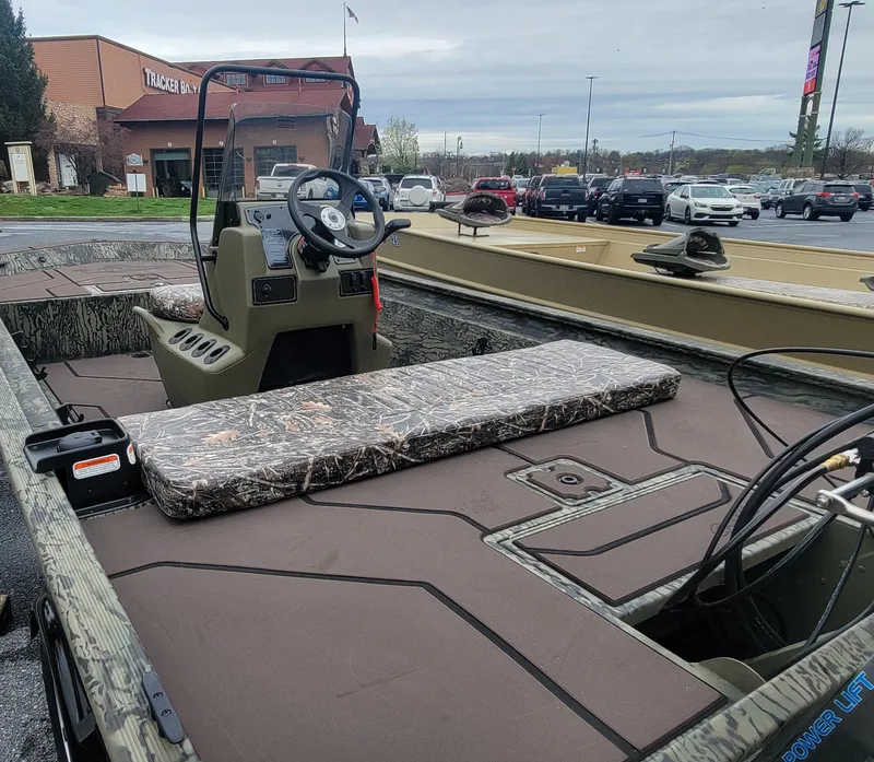 Slide: The Image of 2025 Tracker Grizzly 1860 CC boat interior with steering console and seating. - 6