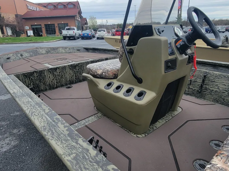 Slide: The Image of 2025 Tracker Grizzly 1860 CC boat interior with camouflage design and steering console. - 7