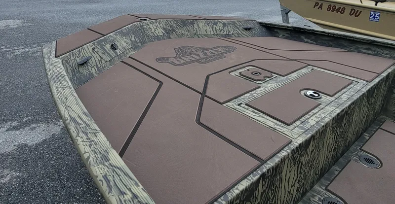 Slide: The Image of 2025 Tracker Grizzly 1860 CC boat deck with camouflage design and storage compartments. - 8
