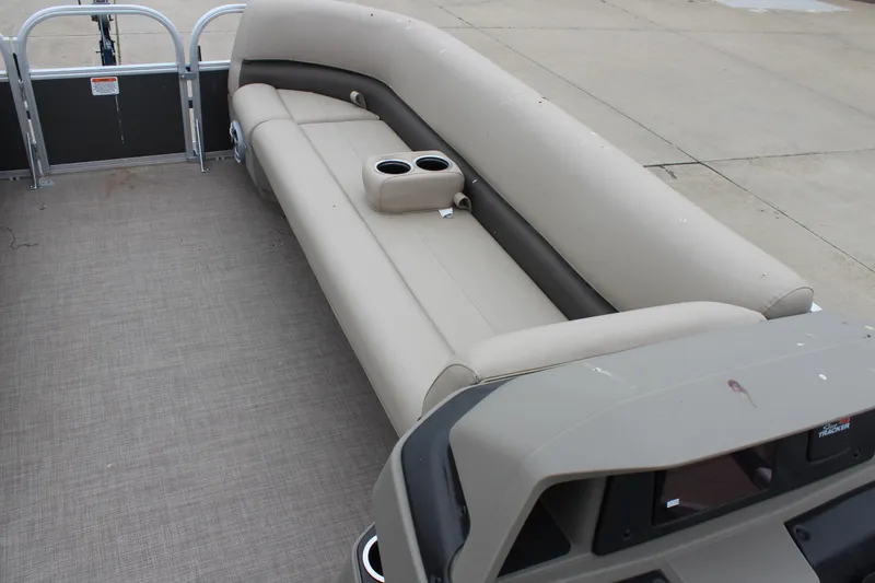 Slide: The Image of 2025 Sun Tracker Party Barge 18 DLX interior with beige seating and cup holders. - 12