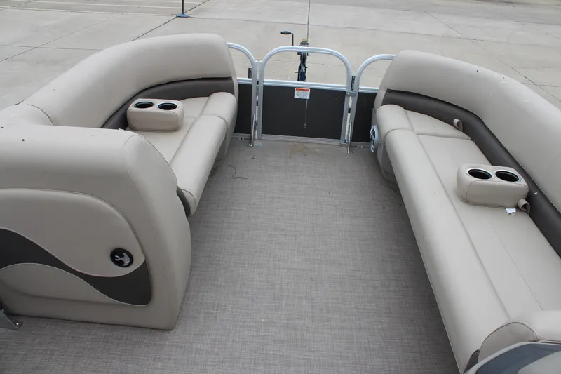 Slide: The Image of 2025 Sun Tracker Party Barge 18 DLX interior with beige seating and cup holders. - 13