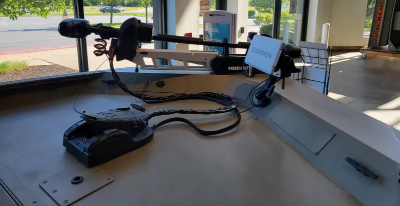 Slide: The Image of 2025 Tracker Grizzly 1860 CC boat with Garmin and Minn Kota equipment in showroom. - 2